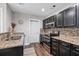 Updated kitchen with dark cabinetry, stainless steel appliances, and granite countertops at 1140 Allgood Rd, Stone Mountain, GA 30083