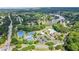 An aerial view of community tennis courts, pool, and clubhouse nestled amongst lush trees and a scenic lake at 2572 Hillgrove Dr, Dacula, GA 30019