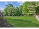 Lush backyard with a well-maintained lawn, mature trees, and a wood privacy fence at 2572 Hillgrove Dr, Dacula, GA 30019