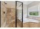 Elegant bathroom with a tiled walk-in shower and soaking tub, accented by warm neutral tones at 2572 Hillgrove Dr, Dacula, GA 30019