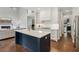 Modern kitchen with blue island open to the living room with fireplace at 2572 Hillgrove Dr, Dacula, GA 30019