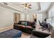 Inviting living room with a plush brown sofa, ottoman, and tray ceiling with recessed lighting at 2572 Hillgrove Dr, Dacula, GA 30019