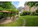 Stone home with charming backyard featuring pergola, swing, fire pit, and lush landscaping at 355 Clark Creek Pass, Acworth, GA 30102