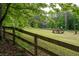 Sprawling backyard featuring a wooden fence, a playground, and mature trees at 355 Clark Creek Pass, Acworth, GA 30102