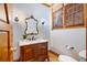 Elegant powder room with an ornate mirror and custom wood vanity with marble countertop at 355 Clark Creek Pass, Acworth, GA 30102