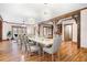 Open-concept dining room featuring hardwood floors, wood beams, modern lighting and formal dining set at 355 Clark Creek Pass, Acworth, GA 30102