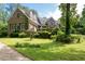 Stately stone house with lush front yard featuring a two-car garage and mature trees at 355 Clark Creek Pass, Acworth, GA 30102