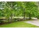 Manicured front yard with a lush lawn and mature trees lining a long driveway at 355 Clark Creek Pass, Acworth, GA 30102