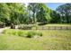 Lush front yard with mature trees, a white fence, and a long driveway at 355 Clark Creek Pass, Acworth, GA 30102