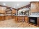 Spacious kitchen featuring custom wood cabinets, an island, wood flooring, and built-in appliances at 355 Clark Creek Pass, Acworth, GA 30102