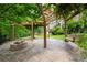 Backyard with a stone firepit and a wooden pergola, complemented by a cozy wooden swing at 355 Clark Creek Pass, Acworth, GA 30102