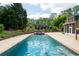 Backyard pool and hot tub feature stone accents, lush landscaping, mature trees, and a private fenced perimeter at 355 Clark Creek Pass, Acworth, GA 30102