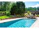 Backyard pool features brick paving, lush landscaping, mature trees, and a hot tub for relaxation at 355 Clark Creek Pass, Acworth, GA 30102