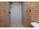 Tiled shower with decorative accent wall, horizontal wood paneling, and matte black hardware at 355 Clark Creek Pass, Acworth, GA 30102