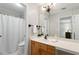 Neutral bathroom with a wood vanity, large mirror, and combination shower and tub at 4390 Wicklow Ct, Suwanee, GA 30024