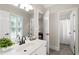 Well-lit bathroom with a large mirror, white vanity, tile floors, and an adjacent shower room at 4390 Wicklow Ct, Suwanee, GA 30024