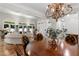 Open-concept dining room with a view of the living area and a large chandelier at 4390 Wicklow Ct, Suwanee, GA 30024
