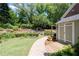 Well-maintained property with a brick pathway leading to a cozy outdoor shed and landscaped gardens in the backyard at 4390 Wicklow Ct, Suwanee, GA 30024