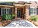 Charming brick front entrance with a decorative door and manicured landscaping at 4390 Wicklow Ct, Suwanee, GA 30024