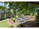 Lush backyard featuring raised garden beds, manicured lawns, and mature trees providing shade and privacy at 4390 Wicklow Ct, Suwanee, GA 30024