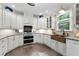 Bright kitchen with white cabinets, granite countertops, stainless steel appliances, and a farmhouse sink at 4390 Wicklow Ct, Suwanee, GA 30024