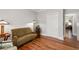 Comfortable living room boasts hardwood floors, an olive sofa, an accent chair, and white trim at 4390 Wicklow Ct, Suwanee, GA 30024