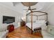 Luxurious main bedroom with a tray ceiling, hardwood floors, and a four-poster bed at 4390 Wicklow Ct, Suwanee, GA 30024