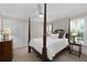 Bedroom boasts a four-poster bed, white linens, neutral walls, and carpet flooring at 4390 Wicklow Ct, Suwanee, GA 30024