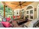 Inviting covered porch with a swing, fan, and comfortable seating area with a fire pit at 4390 Wicklow Ct, Suwanee, GA 30024