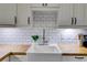 Farmhouse sink detail with butcher block countertops and subway tile backsplash at 959 Hall Nw Pl, Atlanta, GA 30318