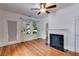 Bright living room with fireplace, hardwood floors, ceiling fan, and large window at 959 Hall Nw Pl, Atlanta, GA 30318