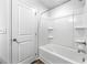 All white bathroom featuring a bright bathtub and shower with built-in shelves at 132 2Nd Nw St, Atlanta, GA 30318