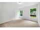 Bright bedroom with neutral carpet, white walls and view of backyard through windows at 132 2Nd Nw St, Atlanta, GA 30318