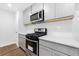 Modern kitchen with stainless steel appliances, gray cabinets, and quartz countertops at 132 2Nd Nw St, Atlanta, GA 30318