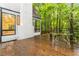 This house has a wood deck with a table, chairs and views of the surrounding trees at 165 River North Walk, Atlanta, GA 30328