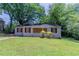 Modest home featuring a front yard with grass, a small covered entryway, and boarded-up windows at 1906 Oak Valley Rd, Decatur, GA 30035