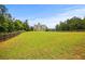 A spacious backyard features a lush green field, a wooden fence and trees, creating a private outdoor space at 237 Arborview Dr, Mcdonough, GA 30252