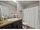 This bathroom features a granite countertop, flowers, a shower with curtain, and modern fixtures, creating an elegant space at 237 Arborview Dr, Mcdonough, GA 30252