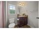 This bathroom features a dark wood vanity, flowers, a window with a view, and modern fixtures, creating an elegant and functional space at 237 Arborview Dr, Mcdonough, GA 30252