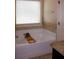 Modern bathtub with a window, neutral tile, and a stylish bath tray at 237 Arborview Dr, Mcdonough, GA 30252