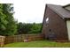 Exterior view of a brick house with a fenced backyard and mature trees at 237 Arborview Dr, Mcdonough, GA 30252