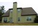 Back of house with green siding, view shows sliding glass door and a tall chimney at 237 Arborview Dr, Mcdonough, GA 30252