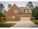 Rear exterior view showcasing a brick facade and a spacious two-car garage at 237 Arborview Dr, Mcdonough, GA 30252