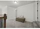 Upstairs hallway with neutral carpet, trim, and an ottoman at 237 Arborview Dr, Mcdonough, GA 30252