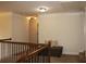 Hallway with a wooden banister, neutral walls, and a cozy seating nook at 237 Arborview Dr, Mcdonough, GA 30252