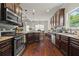 Modern kitchen with stainless steel appliances, granite countertops, and rich wood cabinetry with hardwood floors at 237 Arborview Dr, Mcdonough, GA 30252