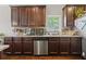 Kitchen showing dark wood cabinets, stainless steel appliances, tile backsplash, and light countertops at 237 Arborview Dr, Mcdonough, GA 30252