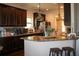 Modern kitchen with dark wood cabinetry, granite countertops, and stainless steel appliances at 237 Arborview Dr, Mcdonough, GA 30252