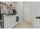 Laundry room with white washer and dryer, tile floor, and wire shelving at 237 Arborview Dr, Mcdonough, GA 30252