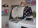 Well-organized laundry room with modern washer and dryer beneath open shelving at 237 Arborview Dr, Mcdonough, GA 30252